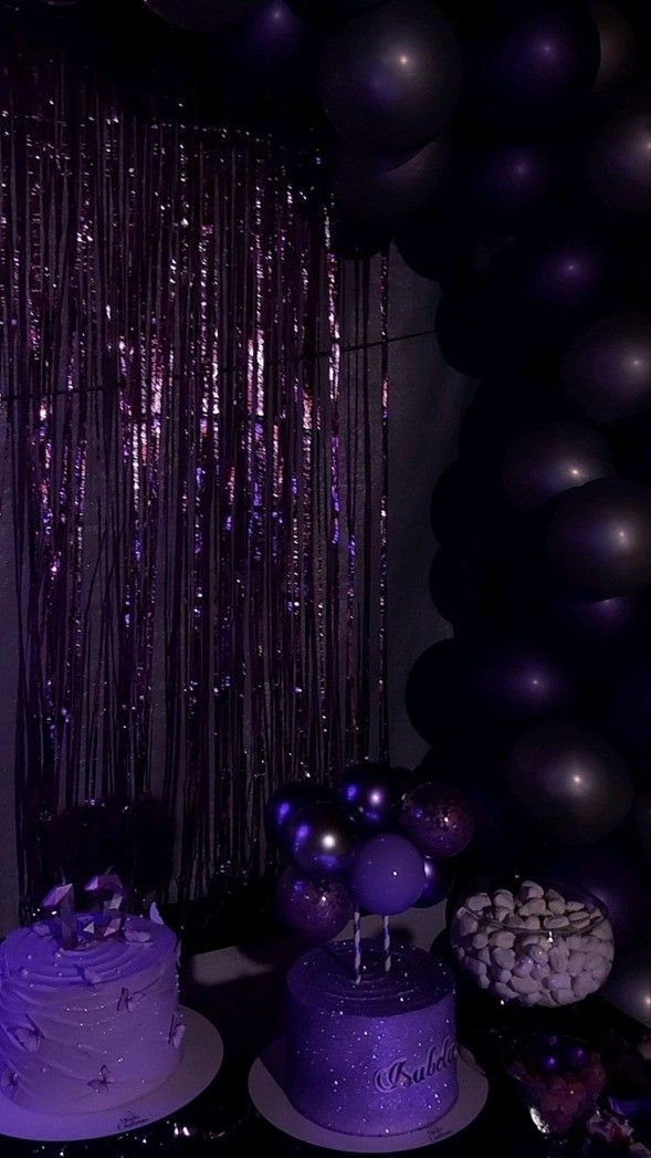 a table topped with purple cake and balloons