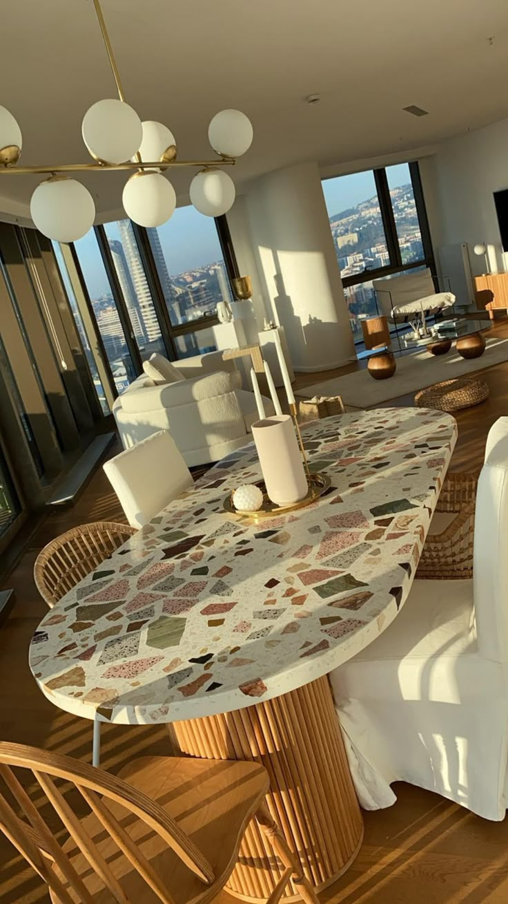 a dining room table and chairs in front of a large window with cityscape on it