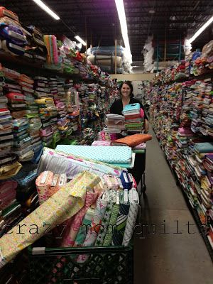 a woman is standing in the aisle of a store filled with lots of wrappings