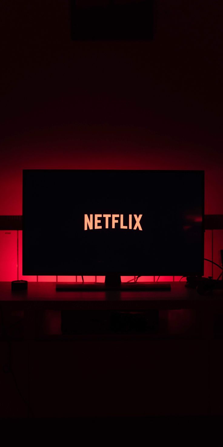 a television screen with the word netflix lit up on it's side in a dark room