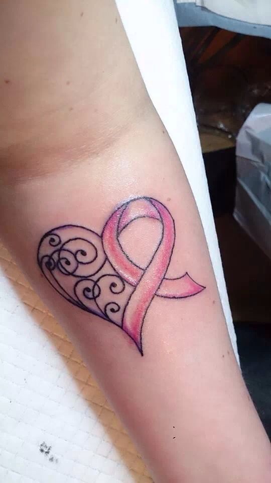 a heart shaped tattoo with a pink ribbon on the side of its arm and an intertwined