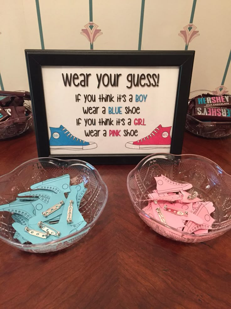 two plastic bowls with pink and blue shoes in front of a sign that says, wear your guess