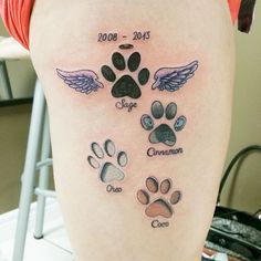 a person with a tattoo on their leg that has dogs paws and angel wings