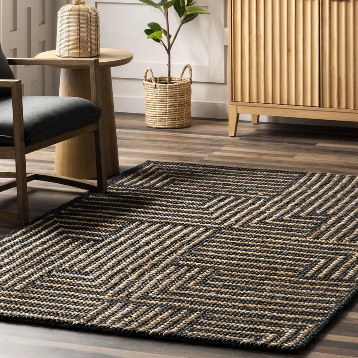 a living room area with a chair, rug and plant in the corner on the floor