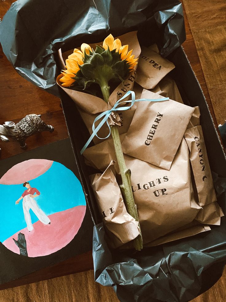 a sunflower is sitting in a box on the floor next to some cards and other items