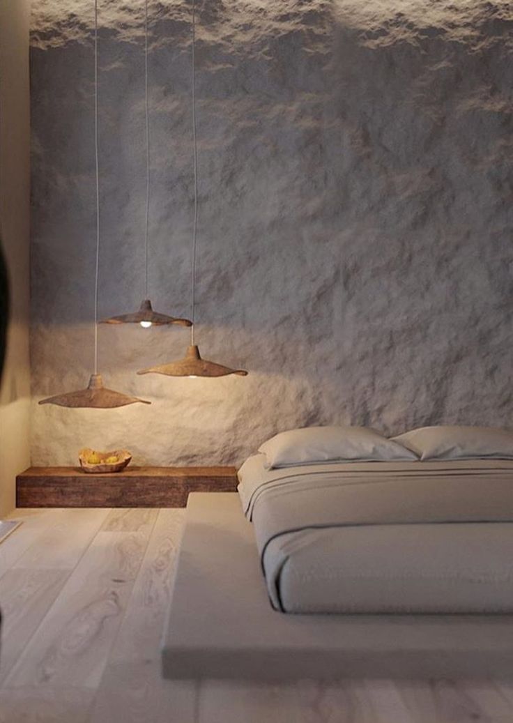 a bed with white sheets and pillows in a room next to a wall that has snow on it