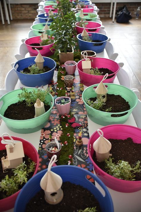 there are many potted plants on the table with tags in each one's buckets