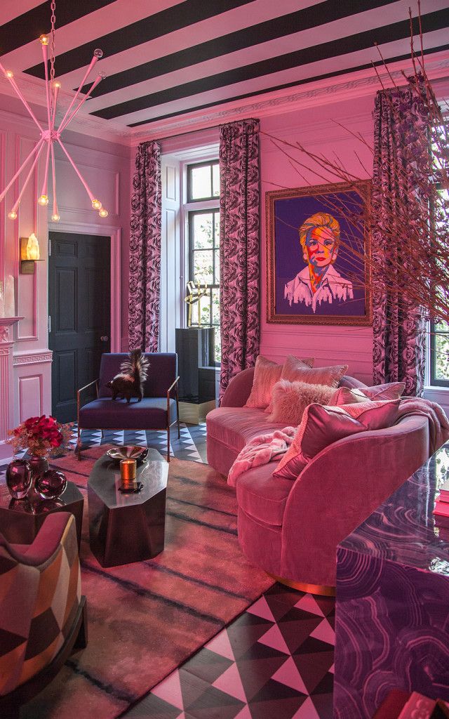 the living room is decorated in pink and black with pops of color on the walls