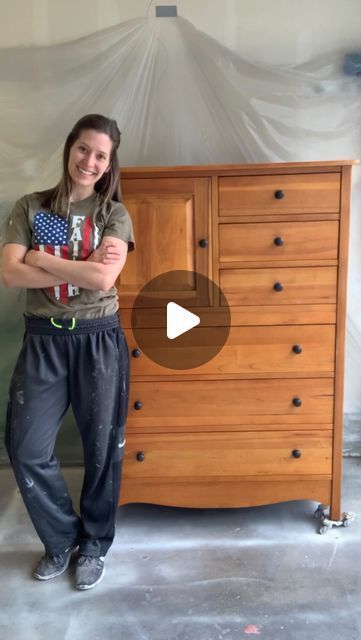 a woman standing next to a wooden dresser