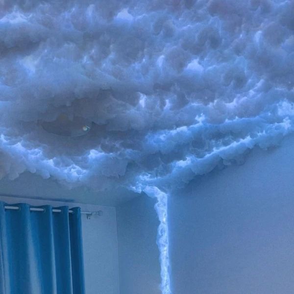 a room with blue curtains and clouds on the ceiling