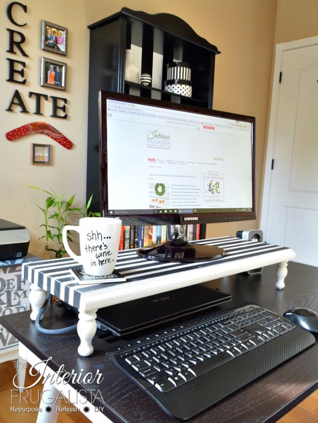 a computer desk with a keyboard, mouse and coffee mug on it in front of a screen