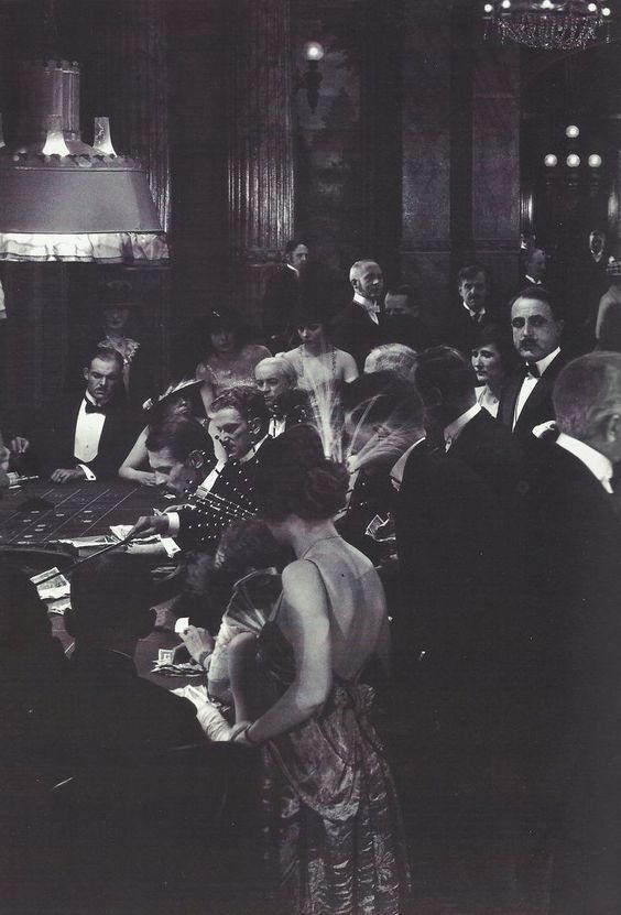 an old black and white photo of people sitting at a table with papers in front of them