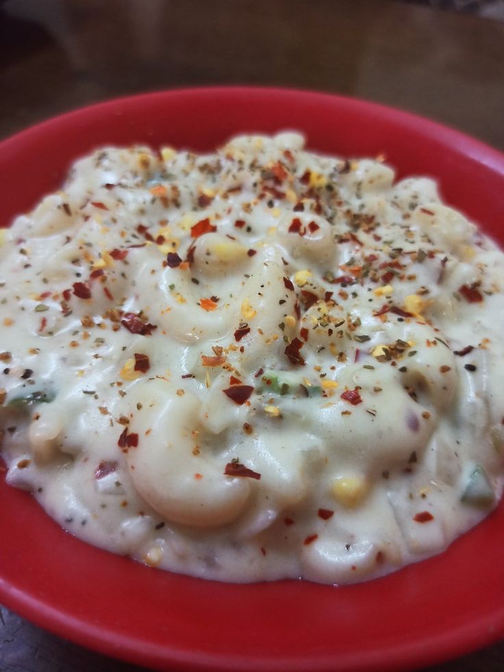 a red plate topped with macaroni and cheese