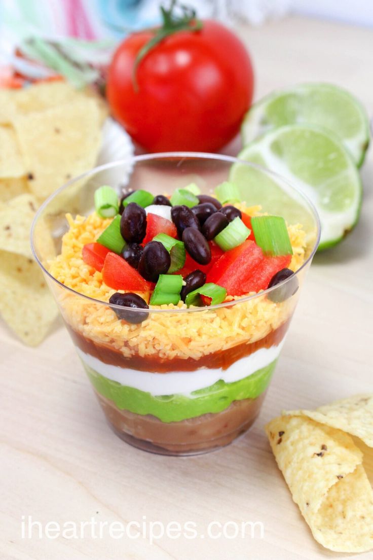 a bowl filled with food next to chips and tomatoes