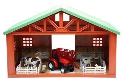 a toy farm with horses, cows and a tractor in front of a barn like structure