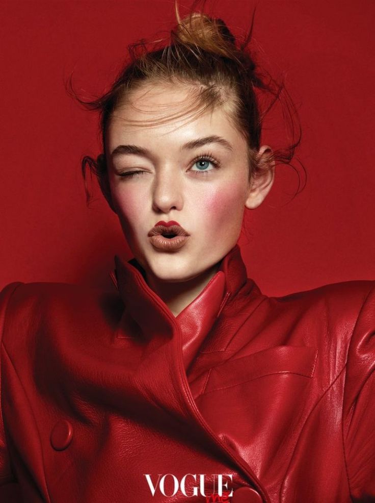 a woman in a red leather jacket posing for the camera