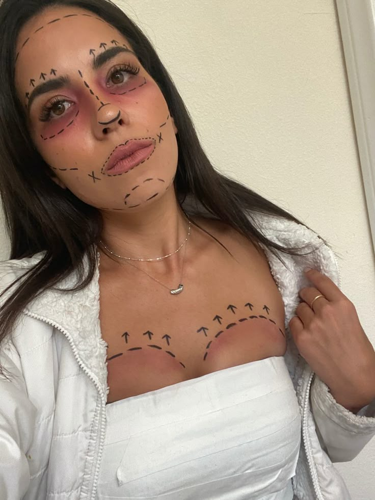 a woman with makeup on her face and chest is posing for the camera while wearing a white shirt