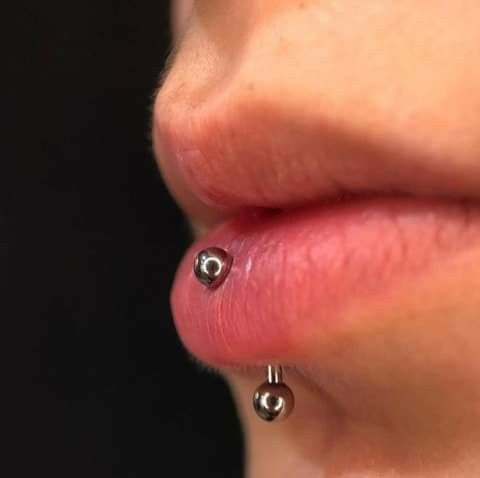 a woman's nose with two piercings attached to the side of her lip