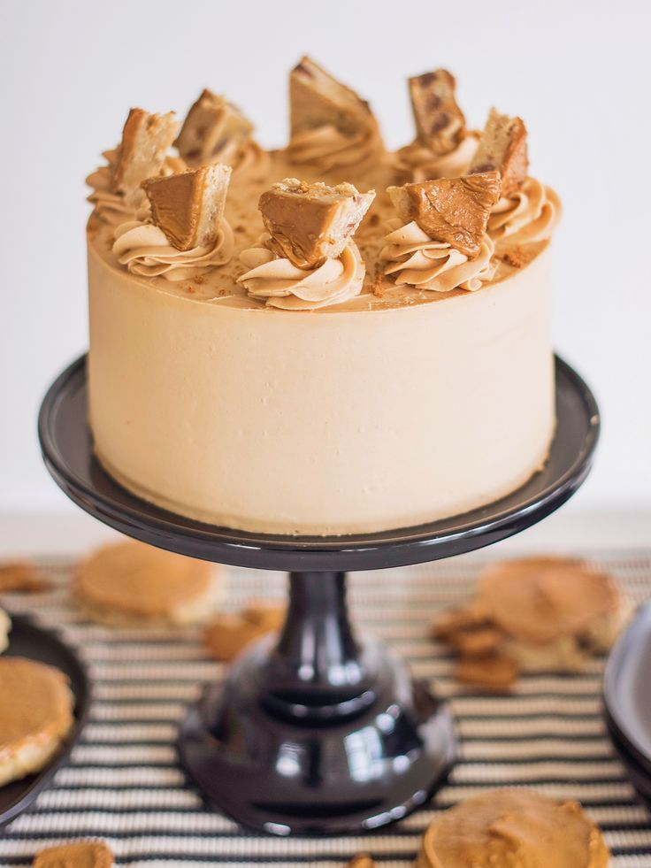 a cake with peanut butter frosting on top and cookies around the edges, sitting on a table