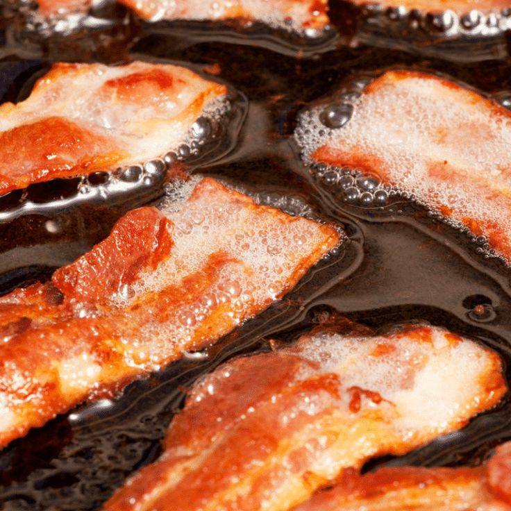 bacon is fried in oil and being cooked