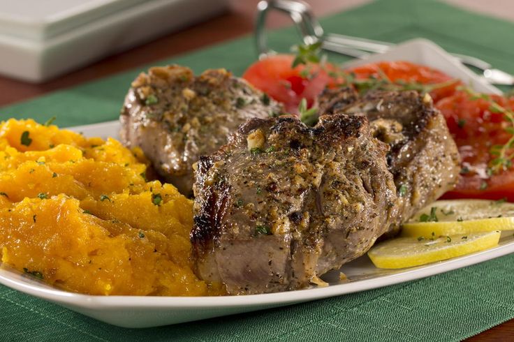 a white plate topped with meat and veggies on top of a green table