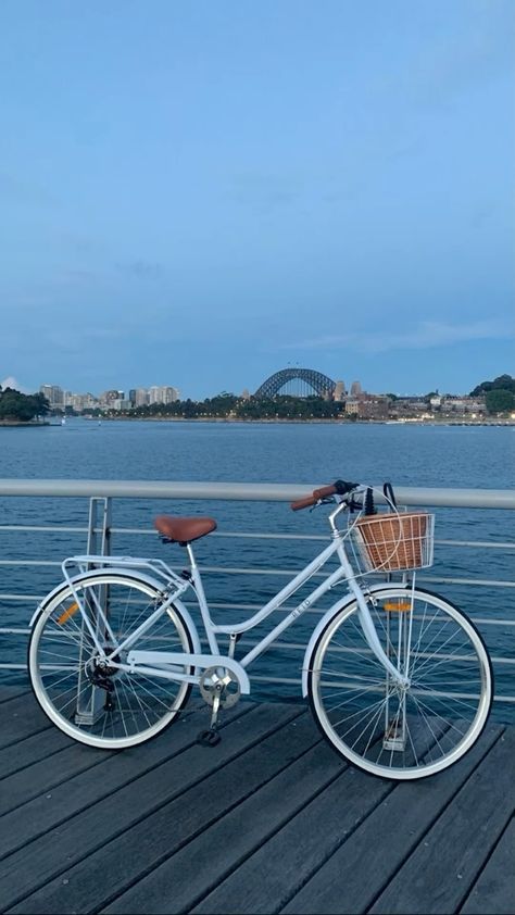 a white bicycle parked on top of a wooden pier