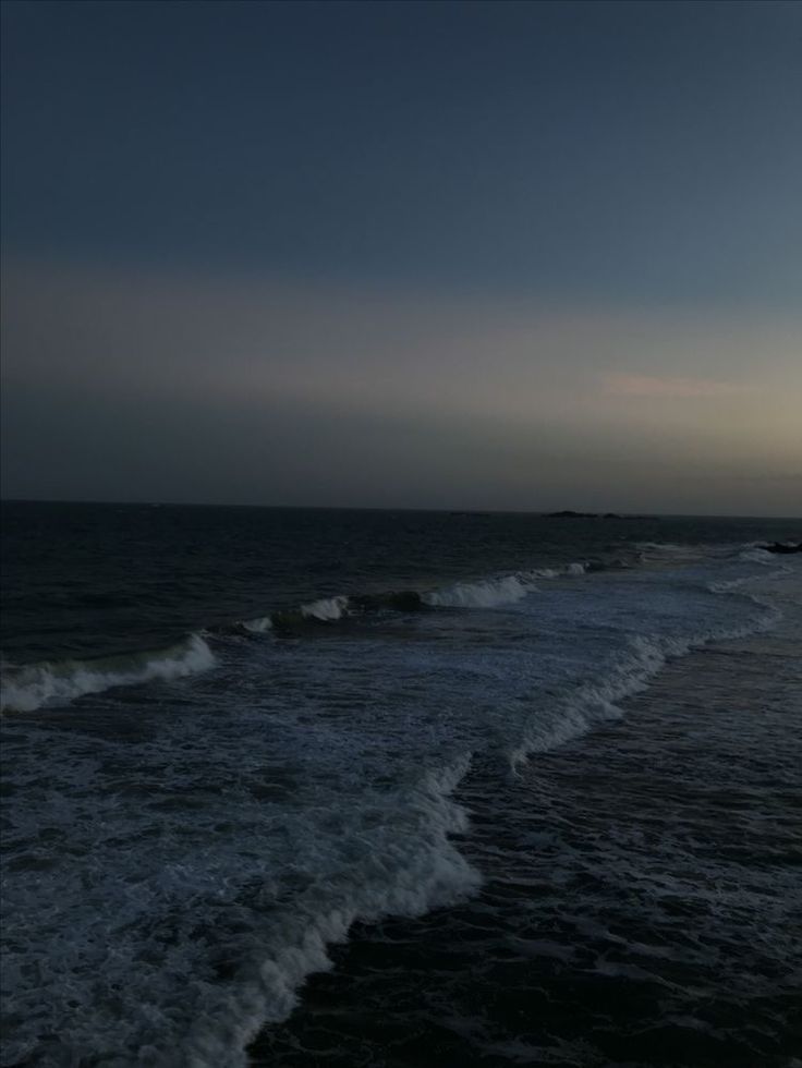 the sun is setting over the ocean with waves