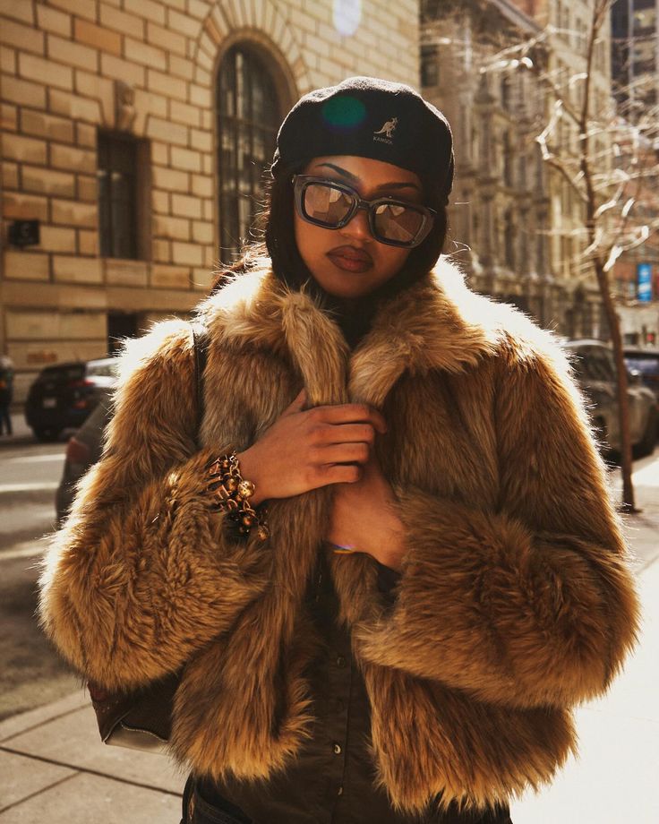 a woman wearing glasses and a fur coat