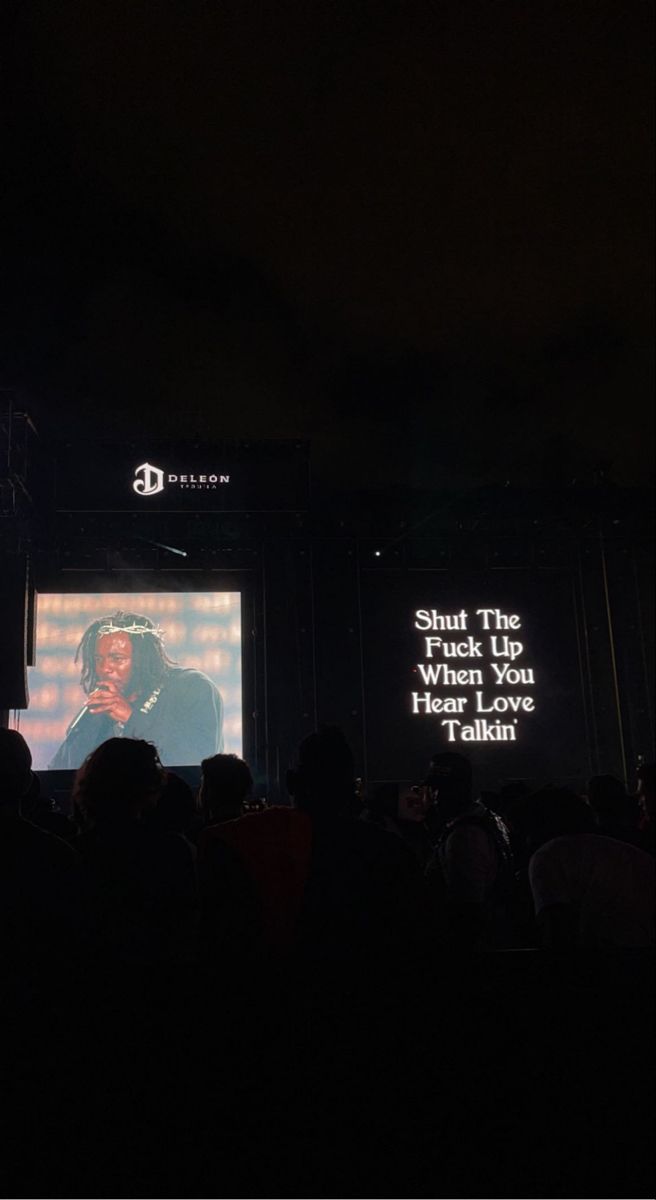 people are watching an event on the big screen in the dark with their cell phones