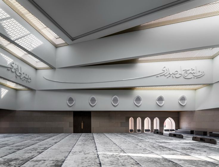 the inside of a large building with many windows and benches in front of each other