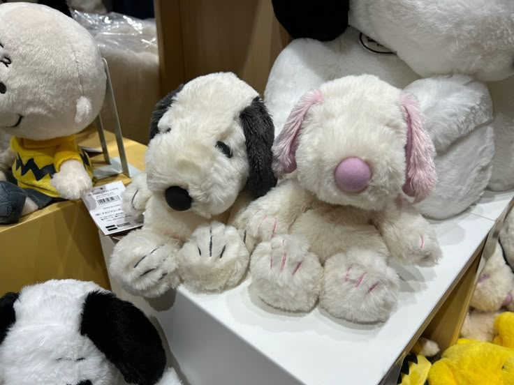 several stuffed animals are on display at a toy store, including one black and white dog