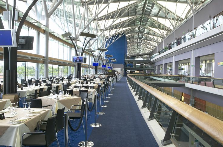 an indoor dining area with tables, chairs and windows on the ceiling is blue carpeted flooring