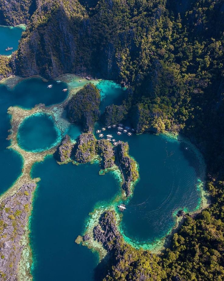 an aerial view of some blue water surrounded by trees