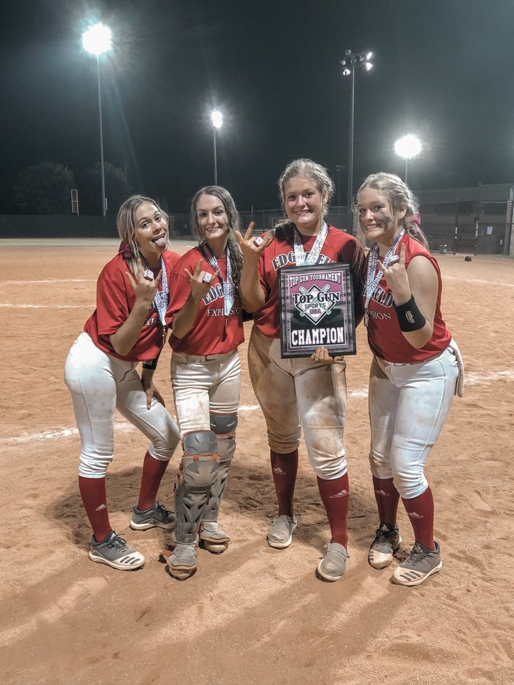 three women in red and white baseball uniforms holding up a plaque