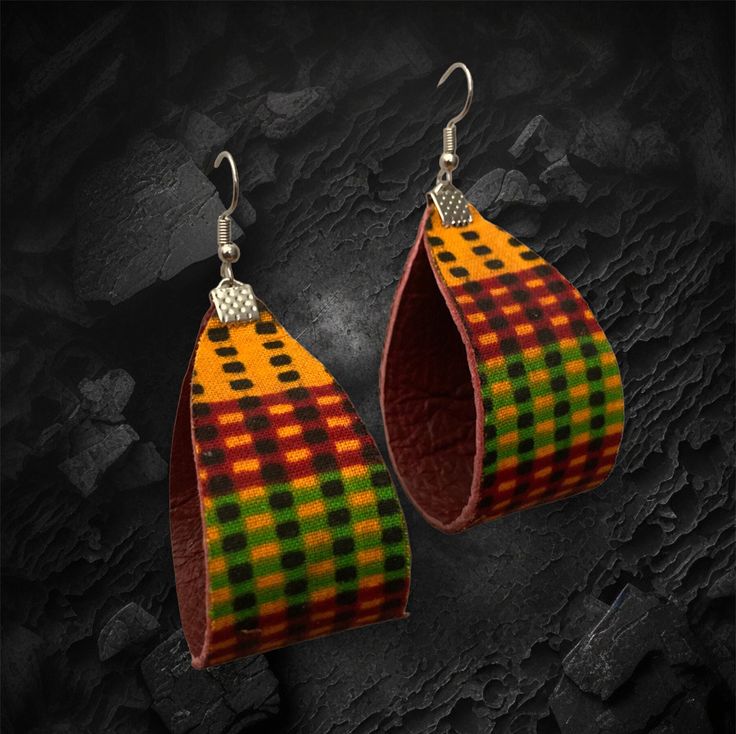 "These versatile, unique and colorful dangle earrings are crafted with genuine deep red leather with traditional Kente pattern in orange, black, red and green. Substantial but not too heavy, they hang 3\" with silver-toned findings and fish hook ear wire." Red Leather Earrings For Gifts, Adjustable Red Leather Earrings, Artisan Red Earrings For Festival, Artisan Red Festival Earrings, Multicolor Hand Tooled Jewelry For Gifts, Multicolor Hand Tooled Jewelry As Gift, Multicolor Hand Tooled Jewelry Gift, Handmade Brown Earrings, Traditional Brown Earrings For Festival