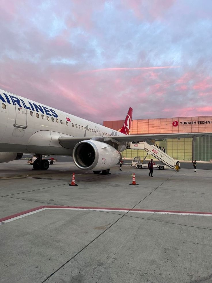 an airplane is parked on the tarmac with stairs leading up to it's door