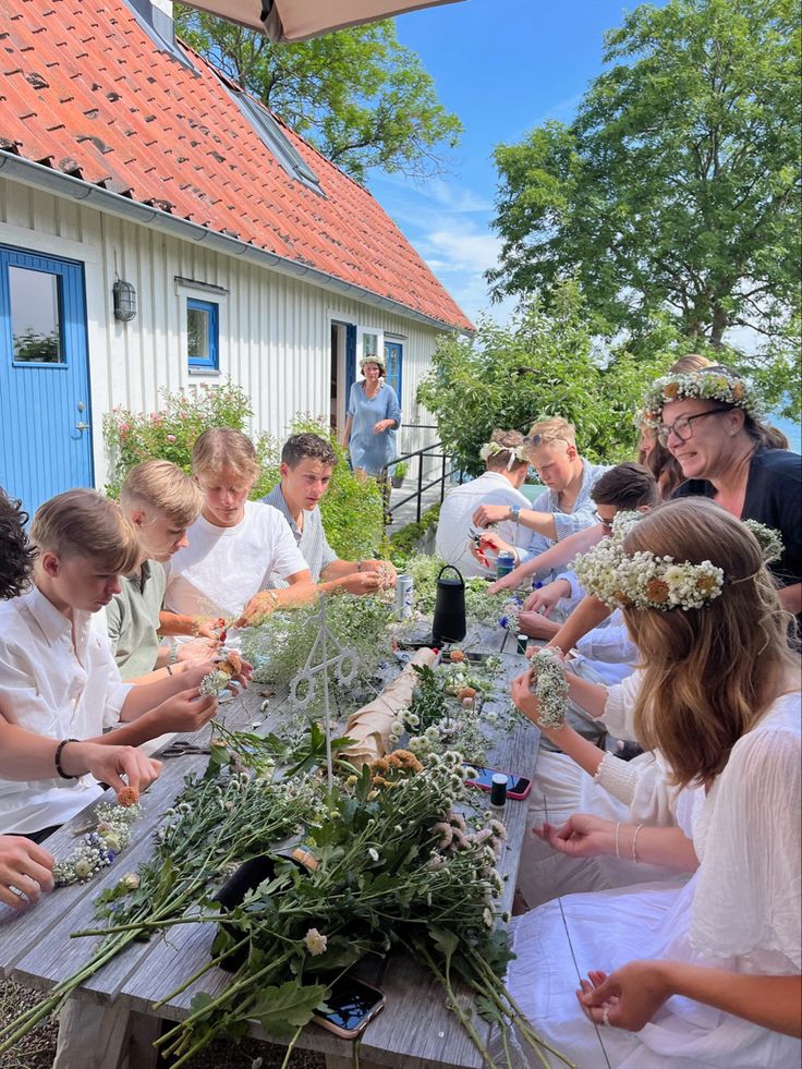 a group of people standing around a table with flowers