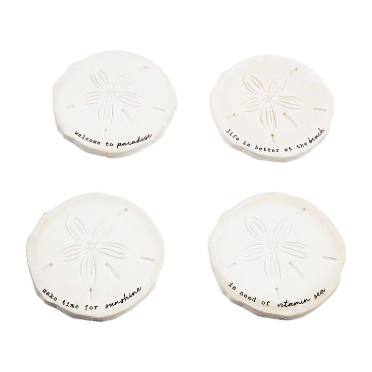 four white sand dollars with writing on them