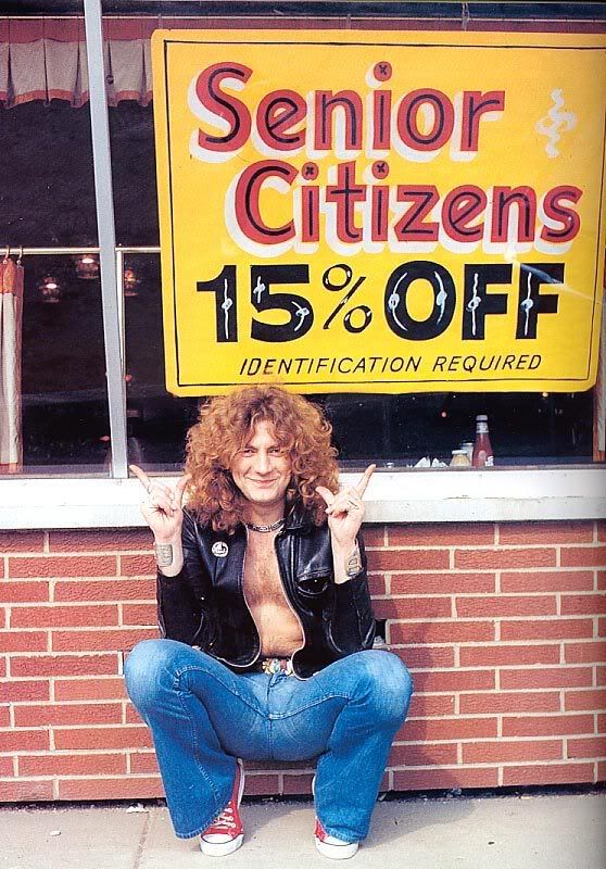 a woman sitting in front of a sign that says robert plant does it better