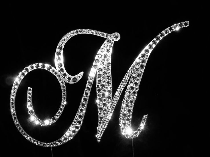 a cake topper with the letter m on it's side and sparkles in the middle