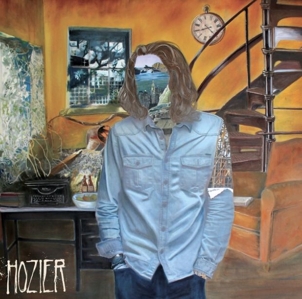 a man standing in front of a painting with the words, hozier on it