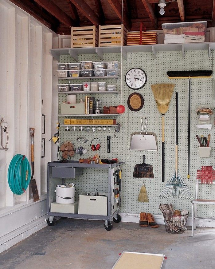 a garage filled with lots of tools and hanging utensils on the wall next to shelves