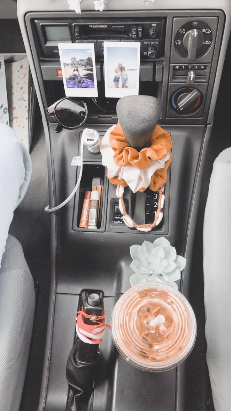 the interior of a car with various items in it and an electronic device on the dash board