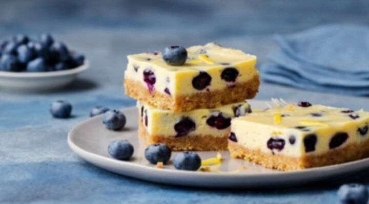 three pieces of cheesecake on a plate with blueberries