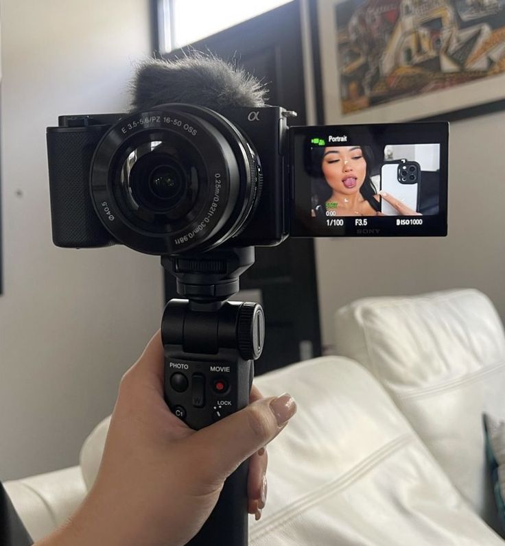 a person holding up a video camera to take a selfie with the phone in front of them