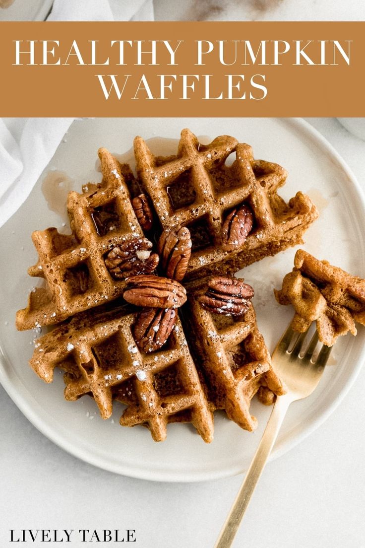 a white plate topped with waffles and pecans on top of a table