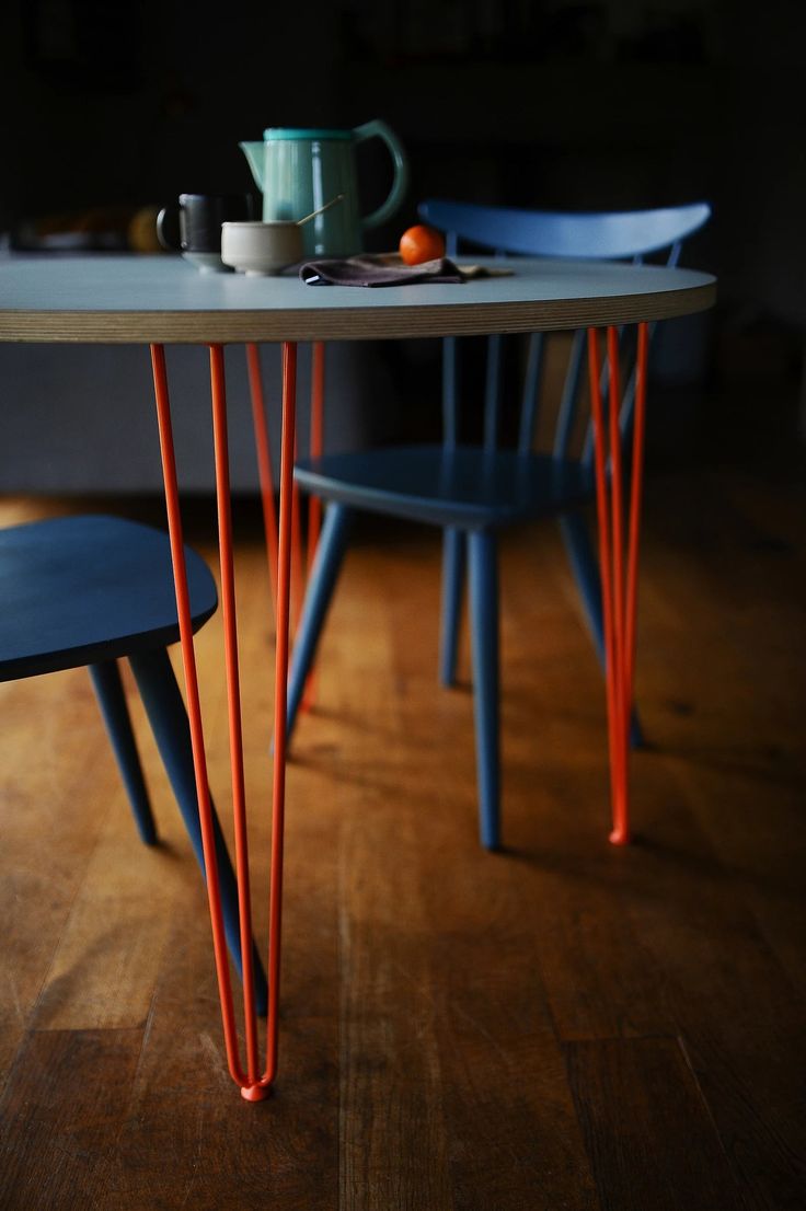 a table with two chairs and a teapot on it, in the dark room