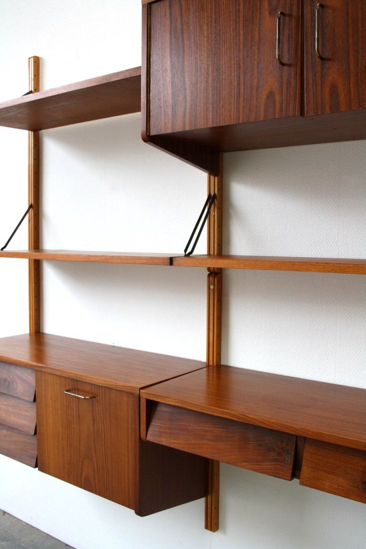 a wall mounted shelf with two drawers and some shelves on the opposite side of it