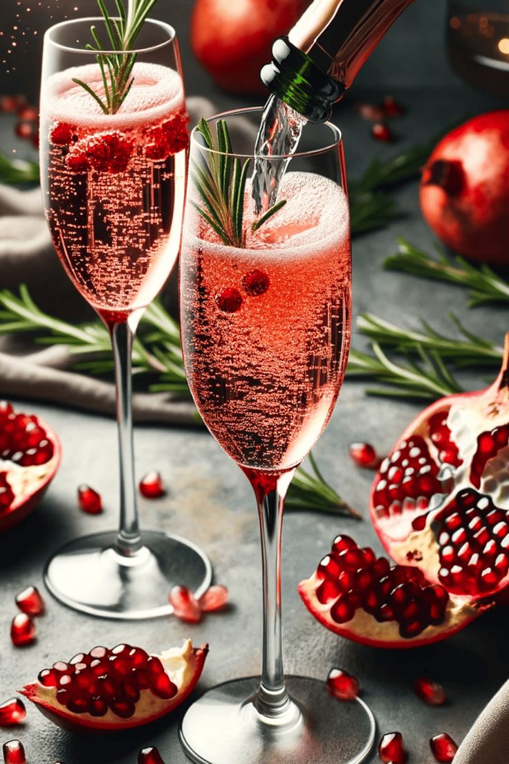 two wine glasses filled with pomegranate and garnished with rosemary