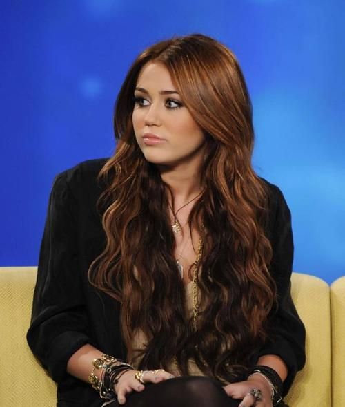 a woman with long hair sitting on a couch